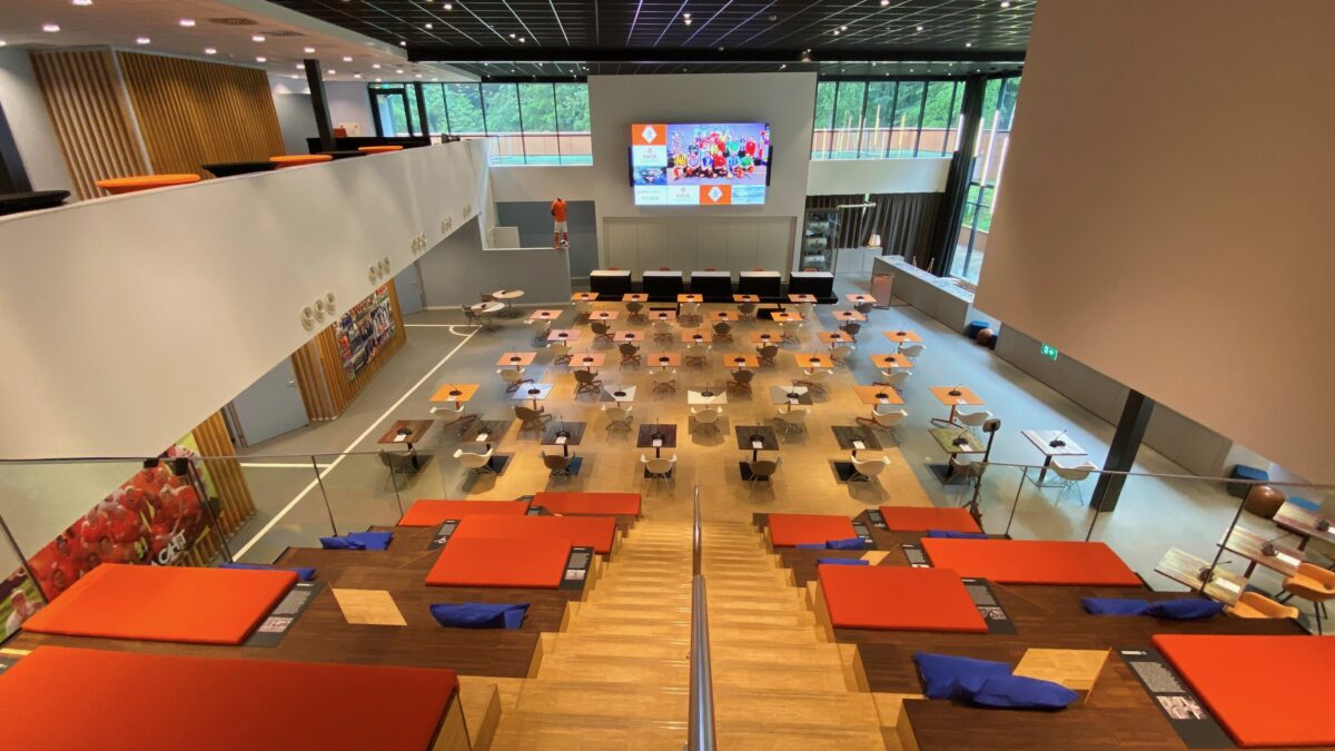 Grote zaal bij KNVB Campus met eenpersoonstafels van bovenaf