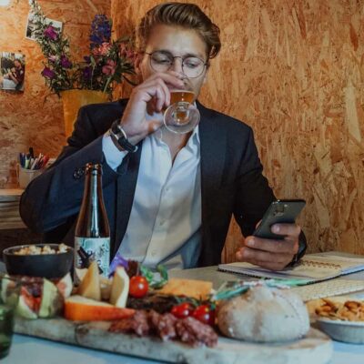 Man die een biertje drinkt tijdens een online meeting met een borrelplank ernaast van Caterbox