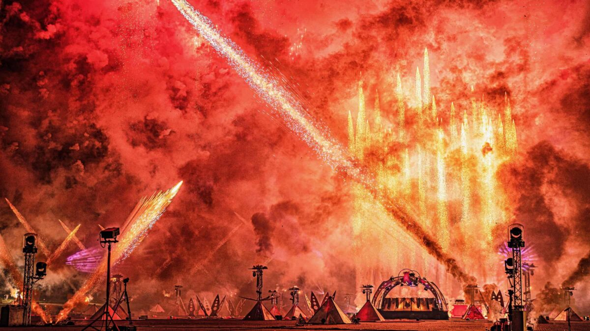 Defqon dj booth met rood en oranje vuurwerk eromheen