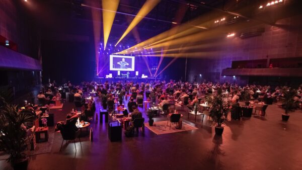 Event van DenkProducties met zitjes op anderhalve meter en een spreker op het podium