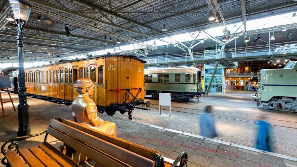 Spoorwegmuseum hal met 3 treinen en een bankje op een perron - Anne Reitsma Fotografie