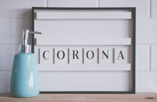 Letterbord met woord corona en een zeeppompje