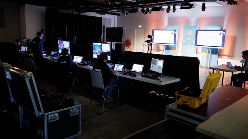 Amplify EventMarketing backstage studio met twee grote schermen en meerdere laptops (Photo: Bram Saeys)