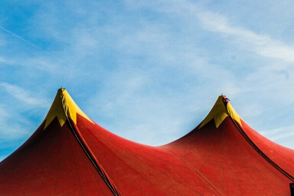 Twee punten van een circustent met een blauwe lucht als achtergrond