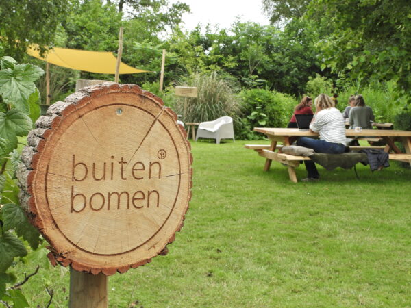 Logo bord buiten bomen