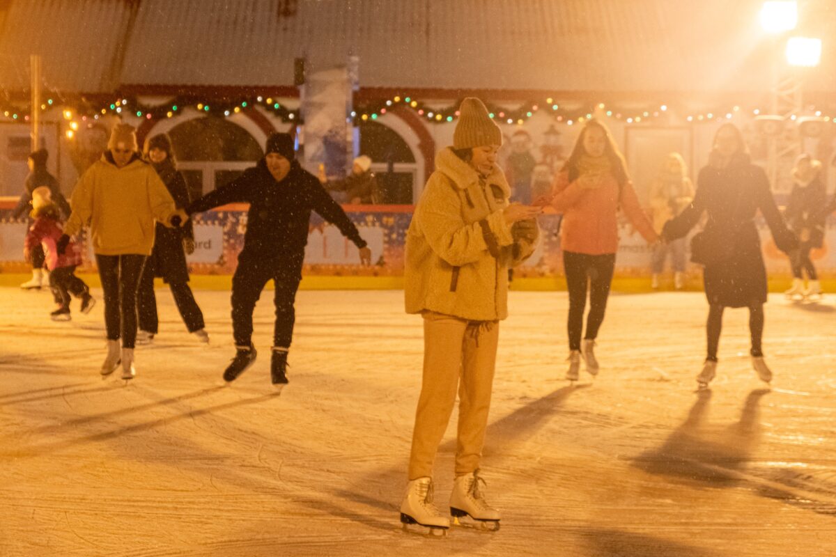 Mensen aan het schaatsen op een verlichte ijsbaan